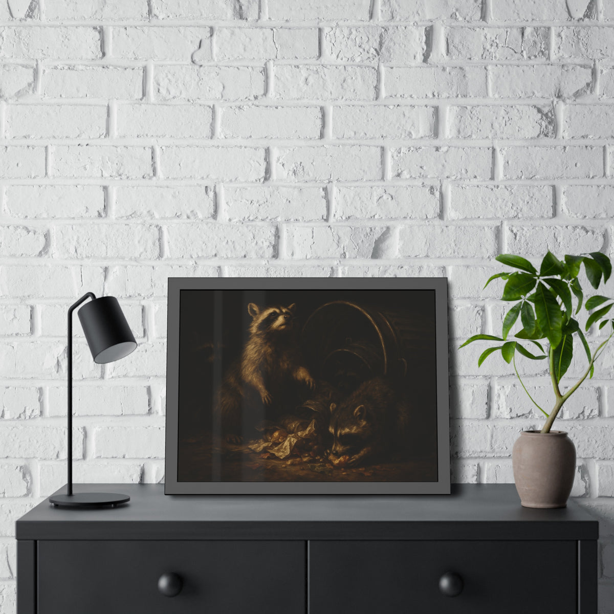 Raccoons feeding on scraps around a tipped metal trash can in the dark. The Calling of St. Trash by Garabaggio, framed fine art print hanging in a room.