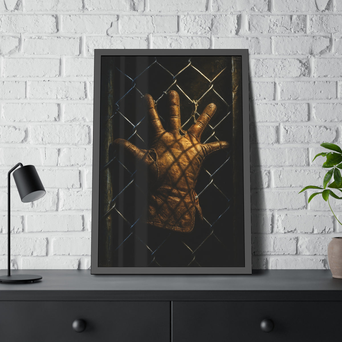 A leather work glove splayed palm out against chain-link wire. The Crucifixion on Chain-Link (Framed) by Garabaggio, framed fine art print hanging in a room.