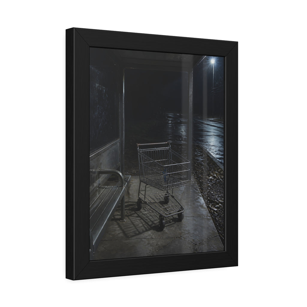 A shopping cart parked inside a bus shelter under a street lamp at night. The Rest at the Bus Shelter by Garabaggio, framed fine art print hanging in a room.