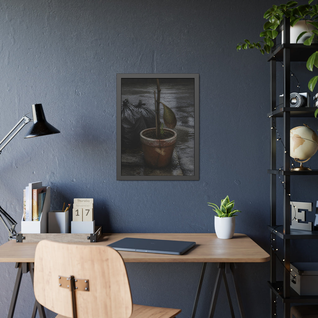 A taped clay pot with one leaf and a green shoot on wet pavement. The Green at the Base by Garabaggio, framed fine art print hanging in a room.