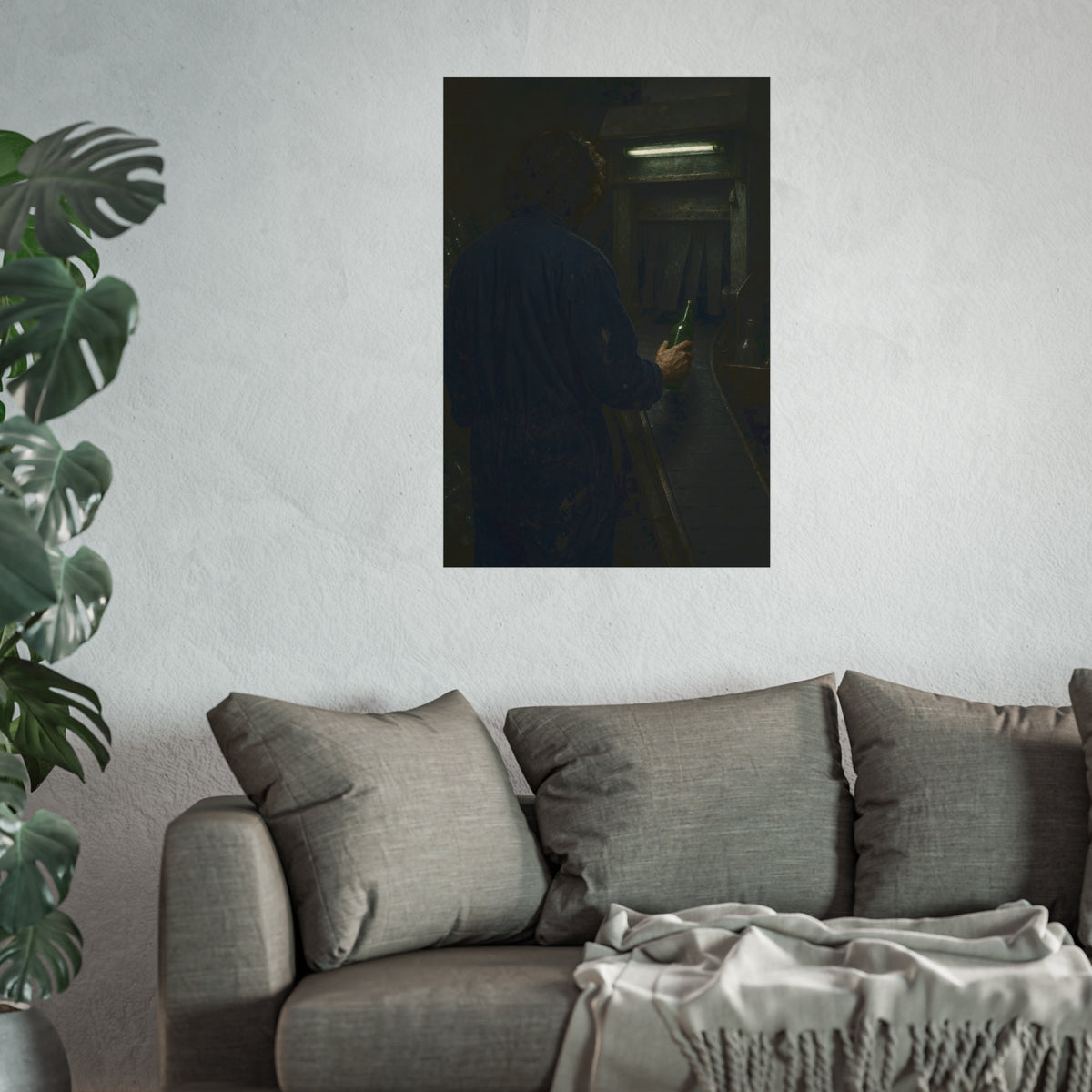 A man in coveralls sets a green bottle on a conveyor under a strip light. Garabaggio at the Conveyor by Garabaggio, fine art print hanging in a room.