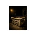 A plastic laundry basket on a basement floor under a bare hanging bulb. The First Split by Garabaggio, fine art print, 12″ x 16″.