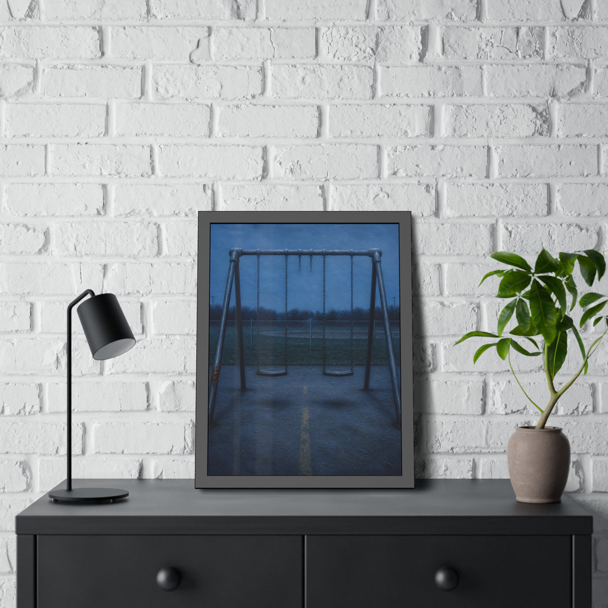 A swing set at dusk with two seats hanging straight. The Sixth Hour: The Seat Hanging Straight by Garabaggio, framed fine art print hanging in a room.
