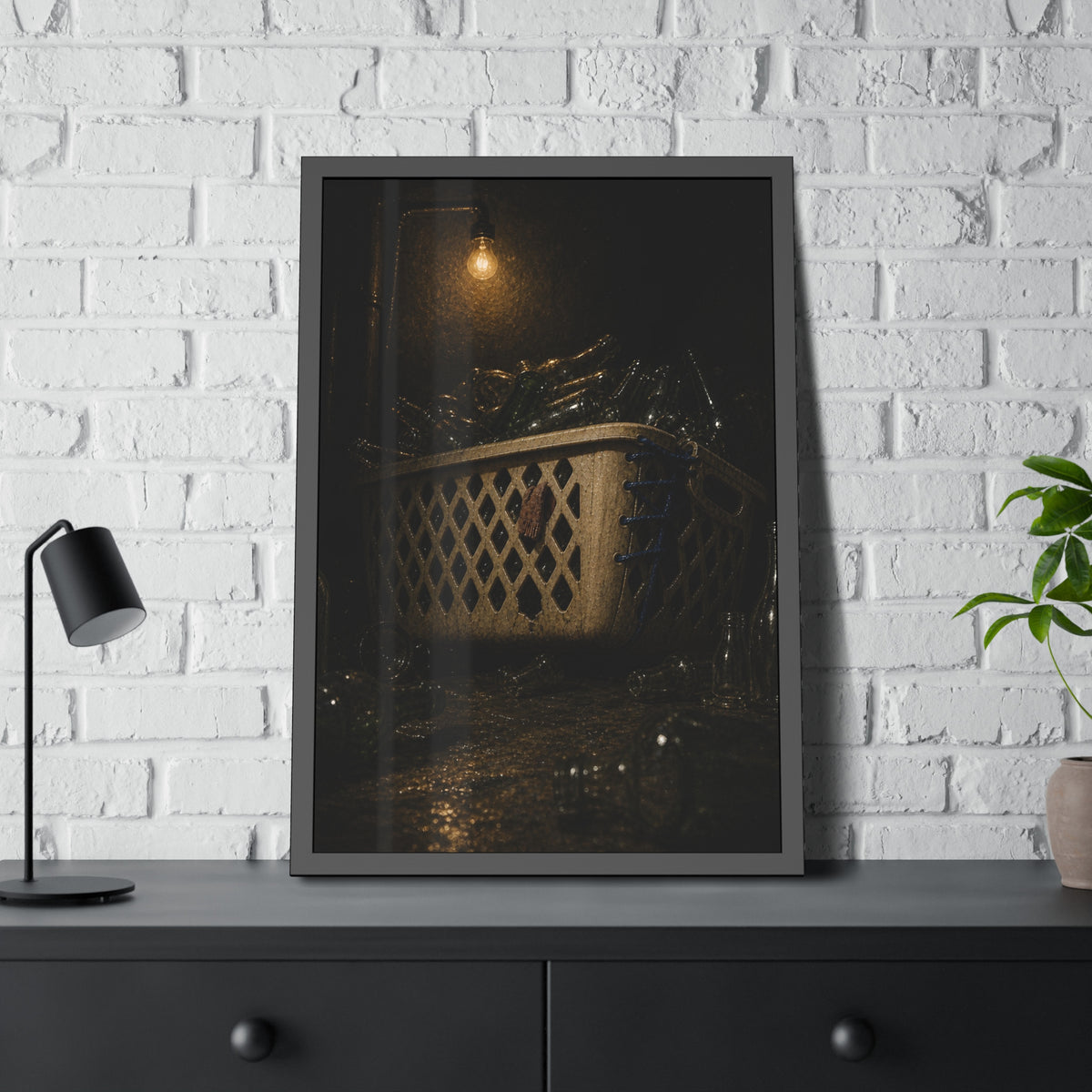 A laundry basket filled with glass bottles under a bare hanging bulb. The Second Life for Bottles by Garabaggio, framed fine art print hanging in a room.