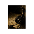 A worn headset resting on a printed script page with coffee rings. The Script Beside the Mouthpiece by Garabaggio, fine art print, 12″ x 16″.