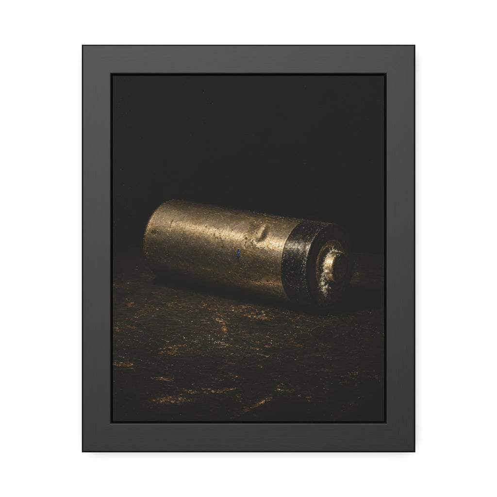 A corroded AA battery lying on a dark gritty surface in a single beam. The First Exhaustion by Garabaggio, framed fine art print, 11″ x 14″.