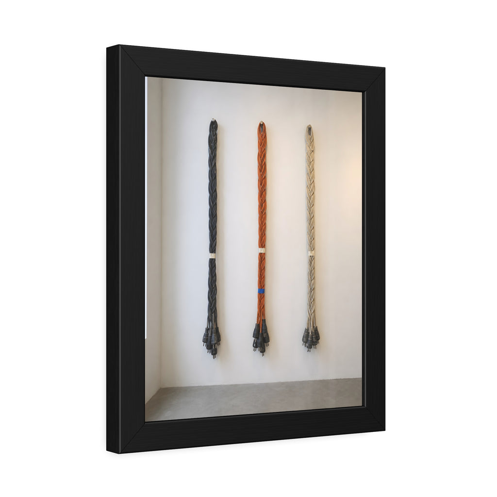 Three braided bundles of extension cords hung on a white gallery wall. The Braided Triptych by Garabaggio, framed fine art print hanging in a room.