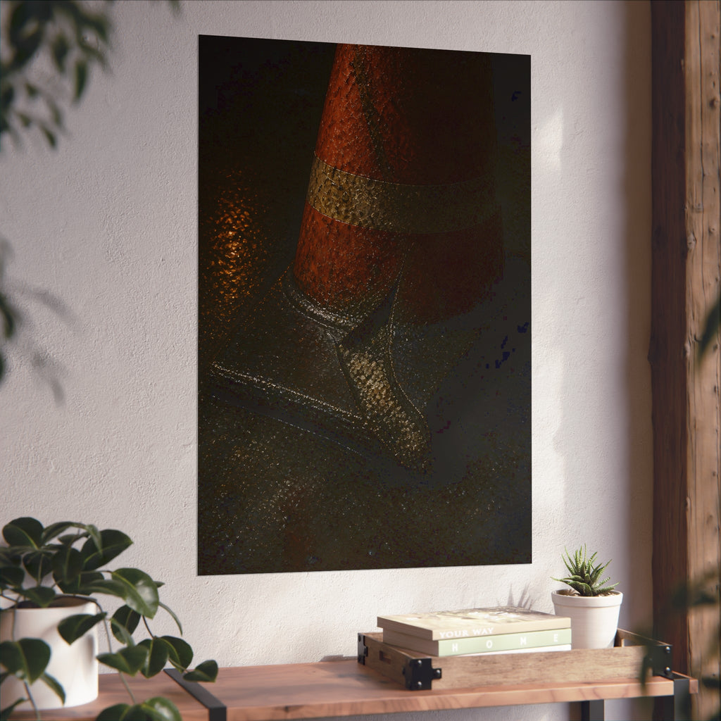 An orange traffic cone with a split base on wet asphalt at night. The Splitting of the Base by Garabaggio, fine art print hanging in a room.