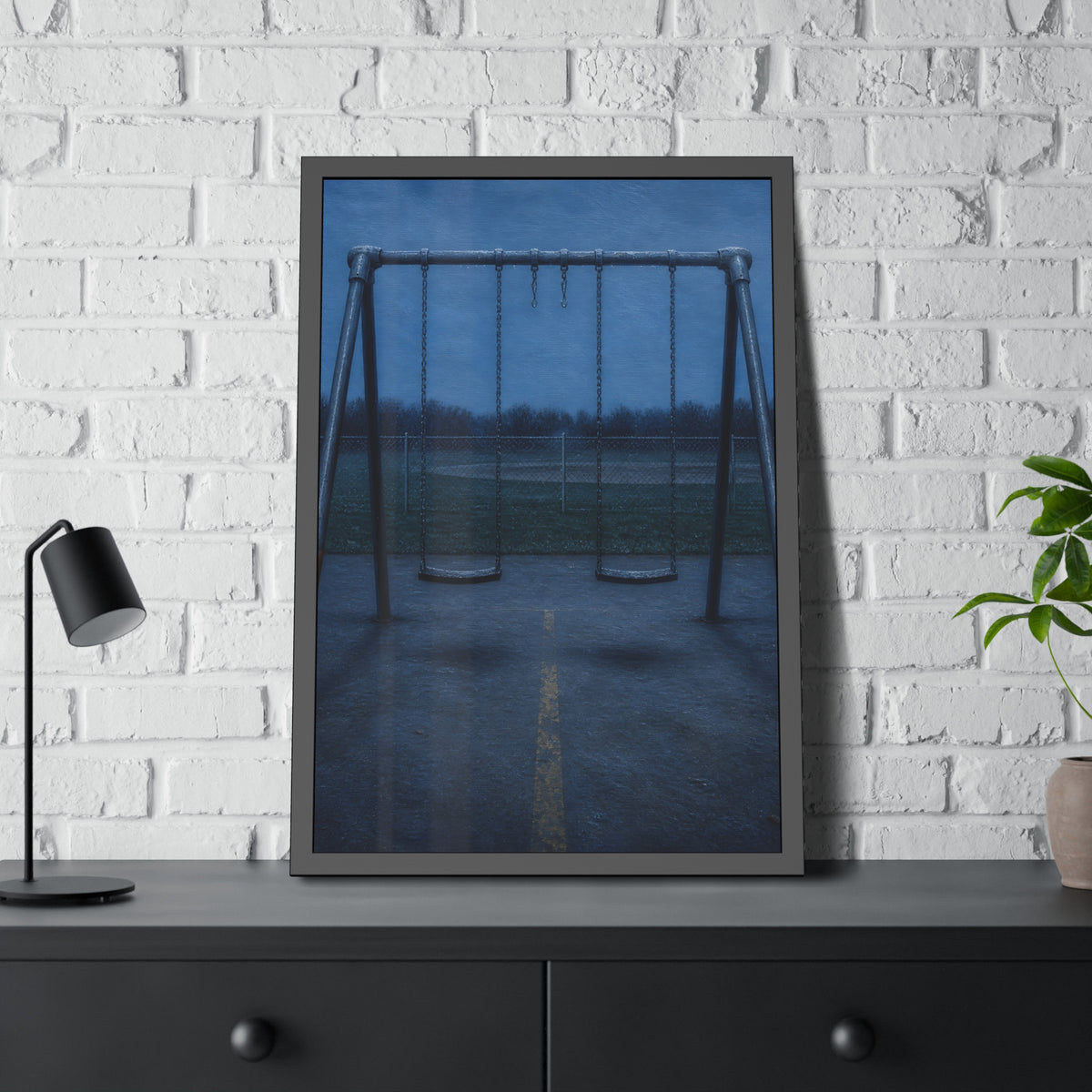 A swing set at dusk with two seats hanging straight. The Sixth Hour: The Seat Hanging Straight by Garabaggio, framed fine art print hanging in a room.