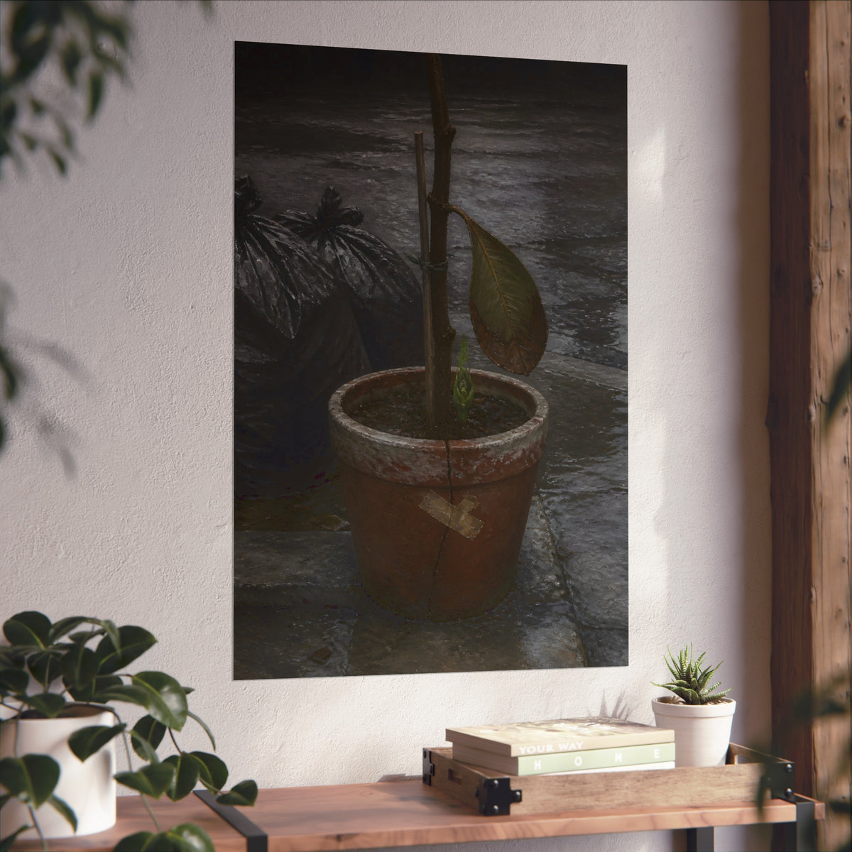 A taped clay pot with one leaf and a green shoot on wet pavement. The Green at the Base by Garabaggio, fine art print hanging in a room.
