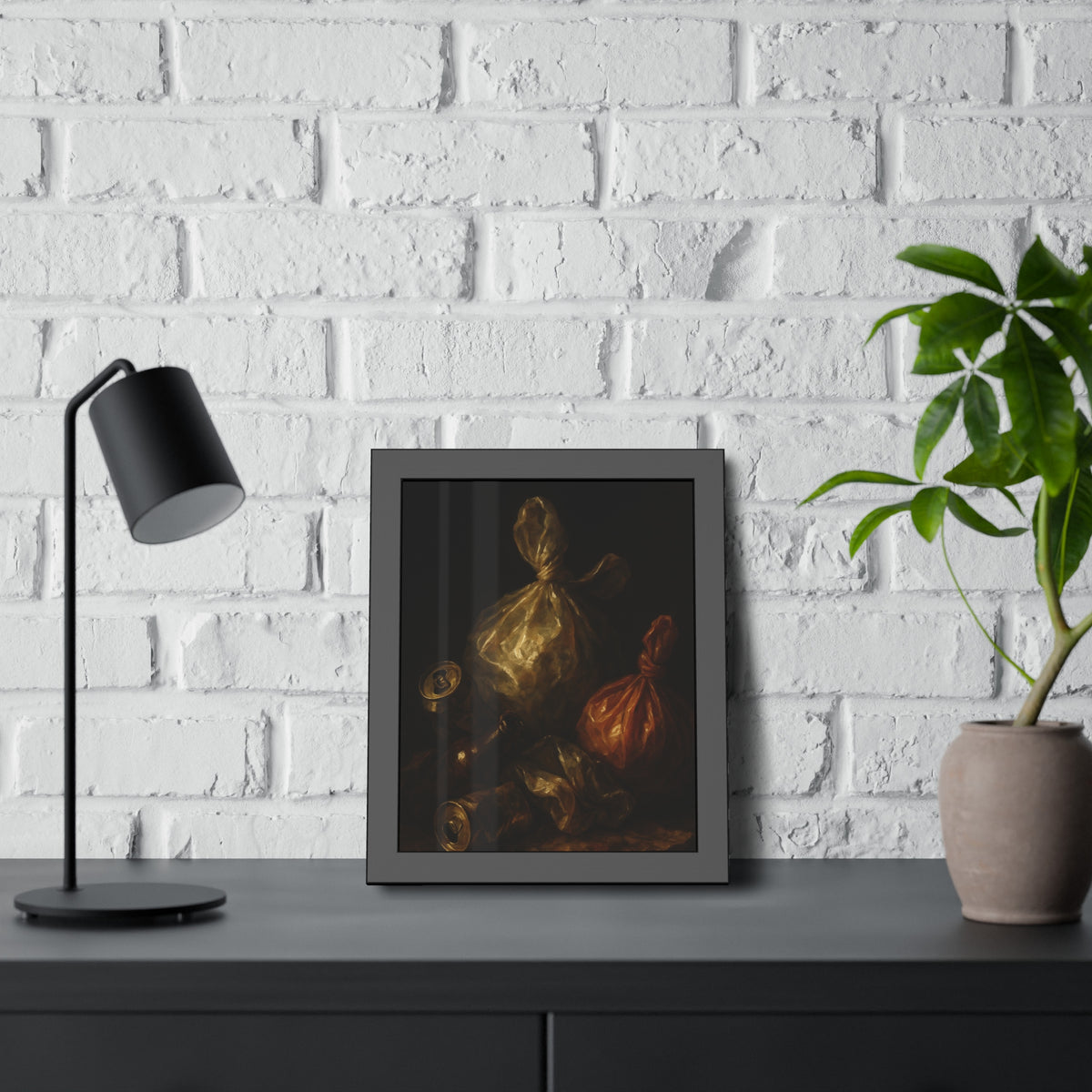 Two knotted plastic bags and crushed cans on a dark table. The Knotted Offering by Garabaggio, framed fine art print hanging in a room.