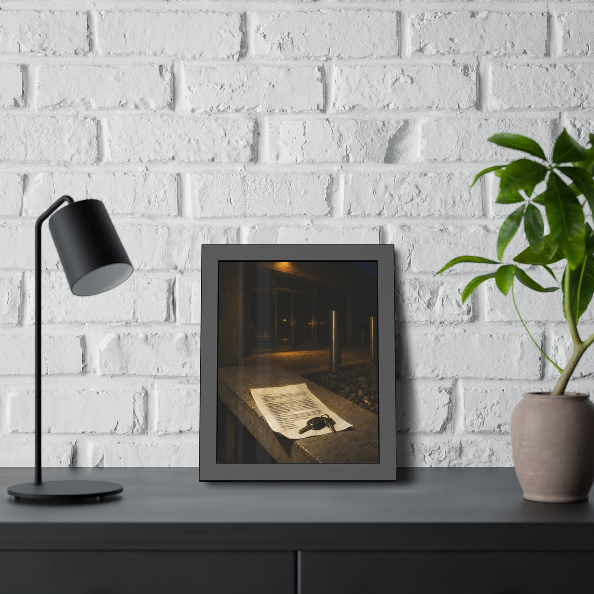 A printed page and car keys on a concrete ledge outside an office at night. The Last Email, Printed by Garabaggio, framed fine art print hanging in a room.