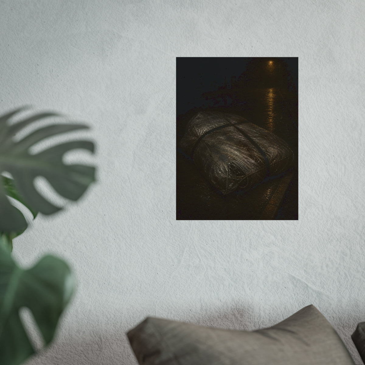 A mattress wrapped in plastic and strapped shut on a wet night street. The Municipal Shroud by Garabaggio, fine art print hanging in a room.