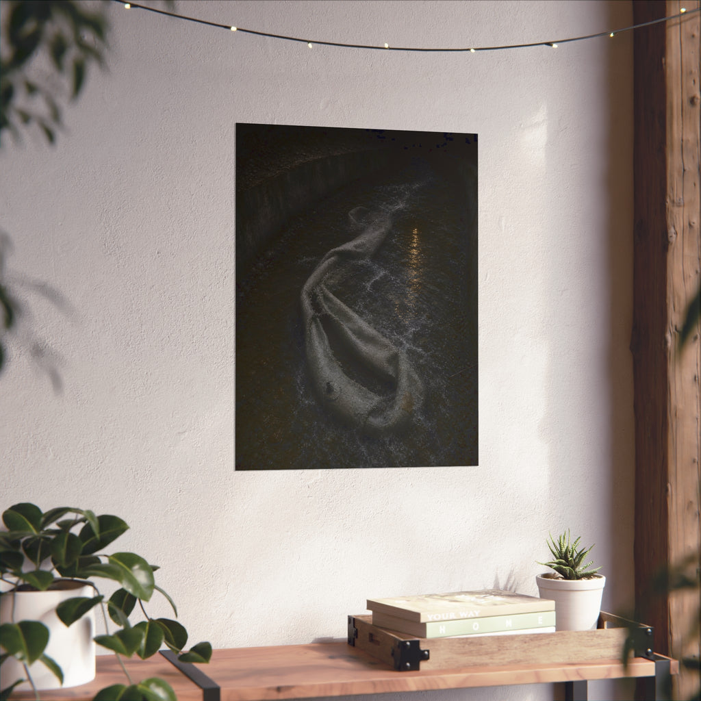 A deflated pool float caught in a concrete drainage channel of running water. The Release into Runoff by Garabaggio, fine art print hanging in a room.