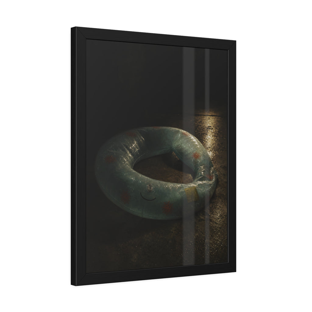 Deflated pool float ring on wet ground, lit from one side in the dark. After the Last Swim by Garabaggio, framed fine art print hanging in a room.