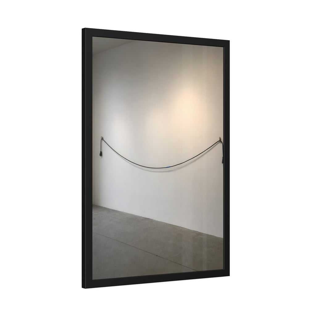 An extension cord hung in a long slack curve across a bare white wall. The Unplugged Line by Garabaggio, framed fine art print hanging in a room.