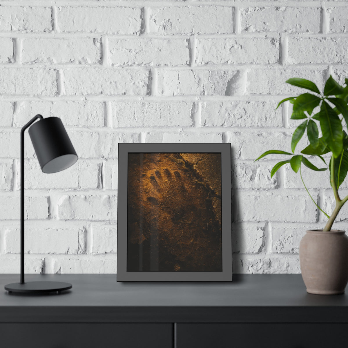 A glove shaped imprint left in cracked asphalt under warm light. The Assumption, or: What Remains by Garabaggio, framed fine art print hanging in a room.