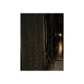 Rows of dark server cabinets with one work lamp glowing far down the aisle. Racks Without Light by Garabaggio, fine art print, 12″ x 16″.