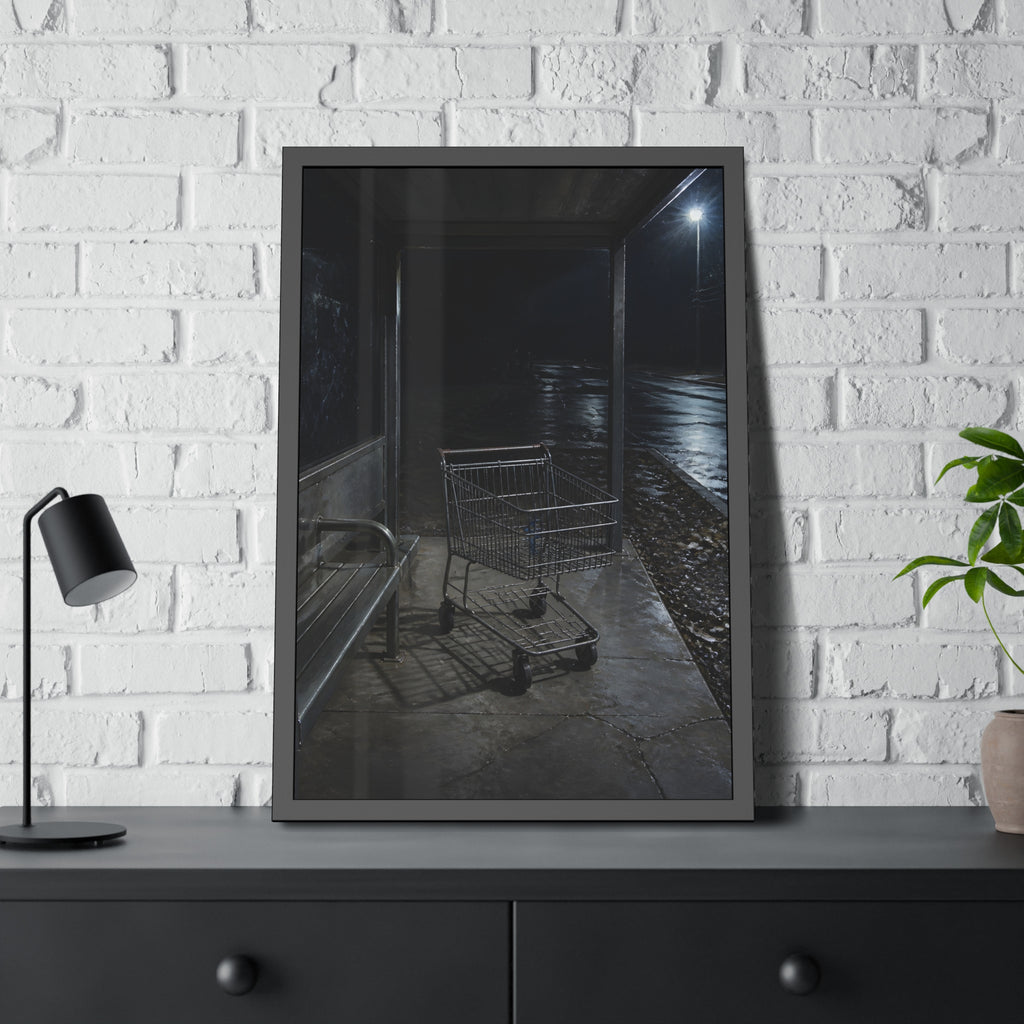 A shopping cart parked inside a bus shelter under a street lamp at night. The Rest at the Bus Shelter by Garabaggio, framed fine art print hanging in a room.
