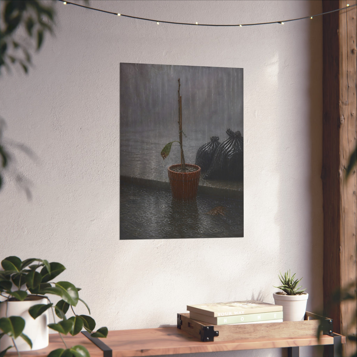 A bare stick in a clay pot on a curb in heavy rain beside trash bags. The Second Rain by Garabaggio, fine art print hanging in a room.