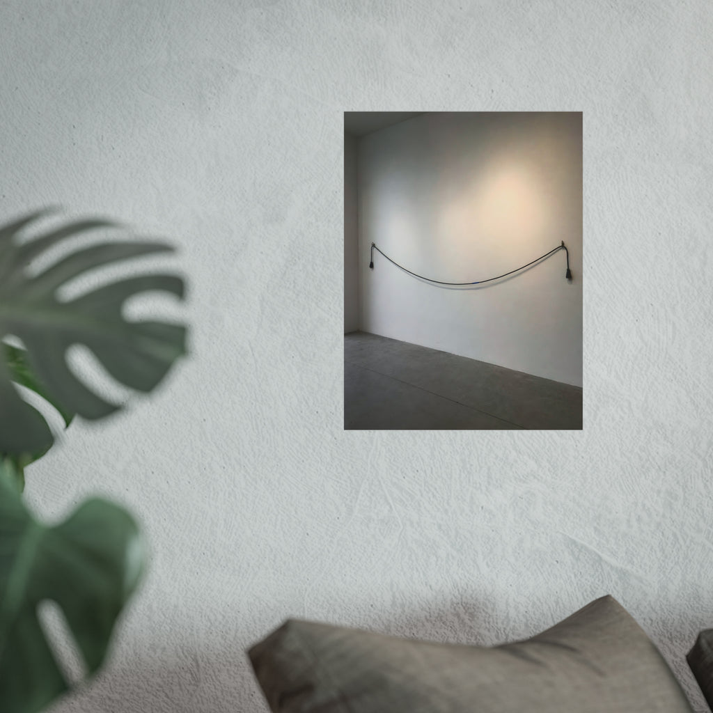 An extension cord hung in a long slack curve across a bare white wall. The Unplugged Line by Garabaggio, fine art print hanging in a room.