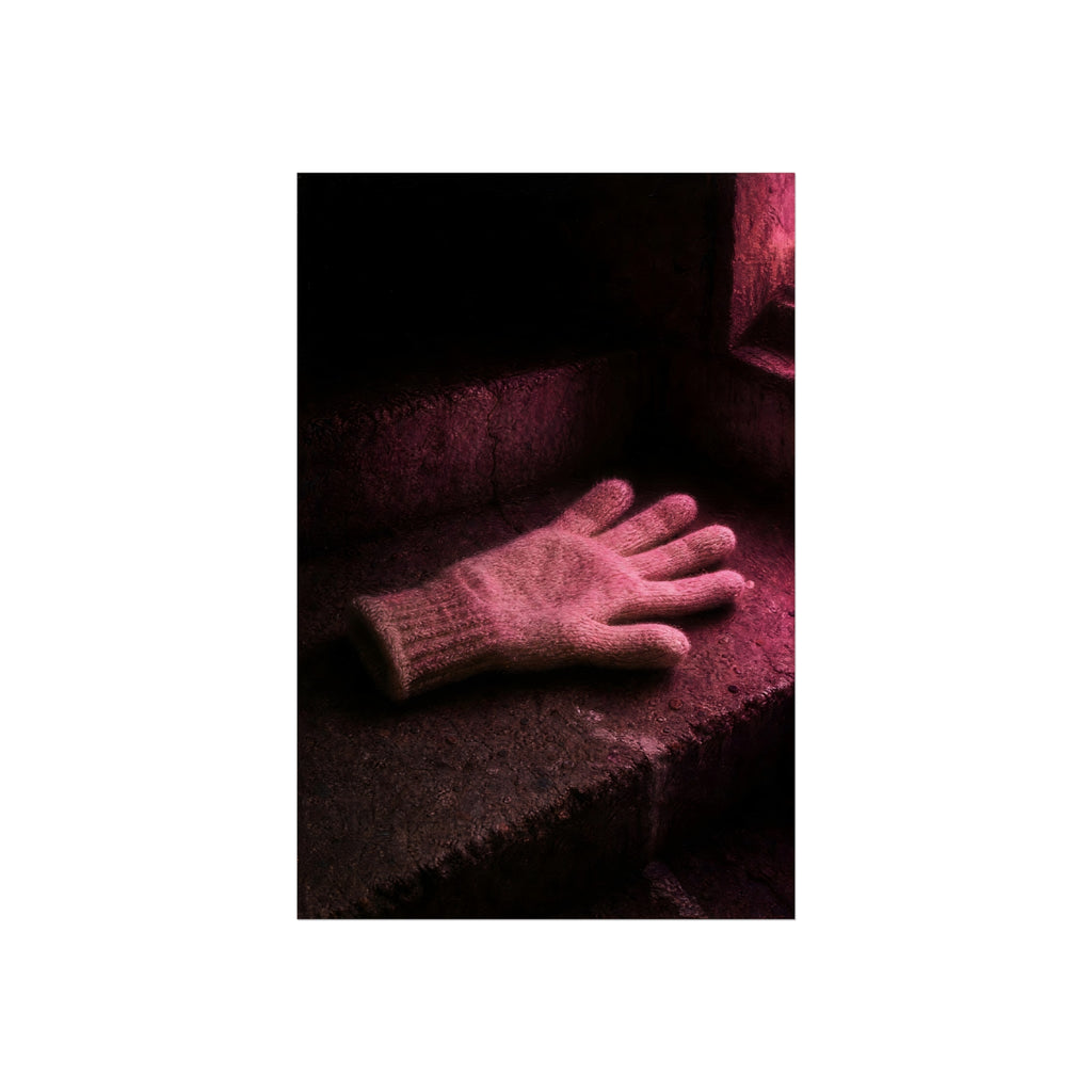 A knitted glove lying flat on a concrete step under pink light. The Vigil in Pink Light by Garabaggio, fine art print hanging in a room.