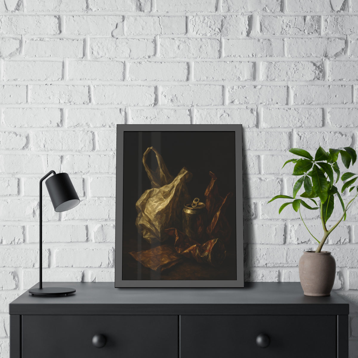 A crumpled plastic bag, crushed can and foil wrappers on a dark table. The Pietà of the Deflated by Garabaggio, framed fine art print hanging in a room.