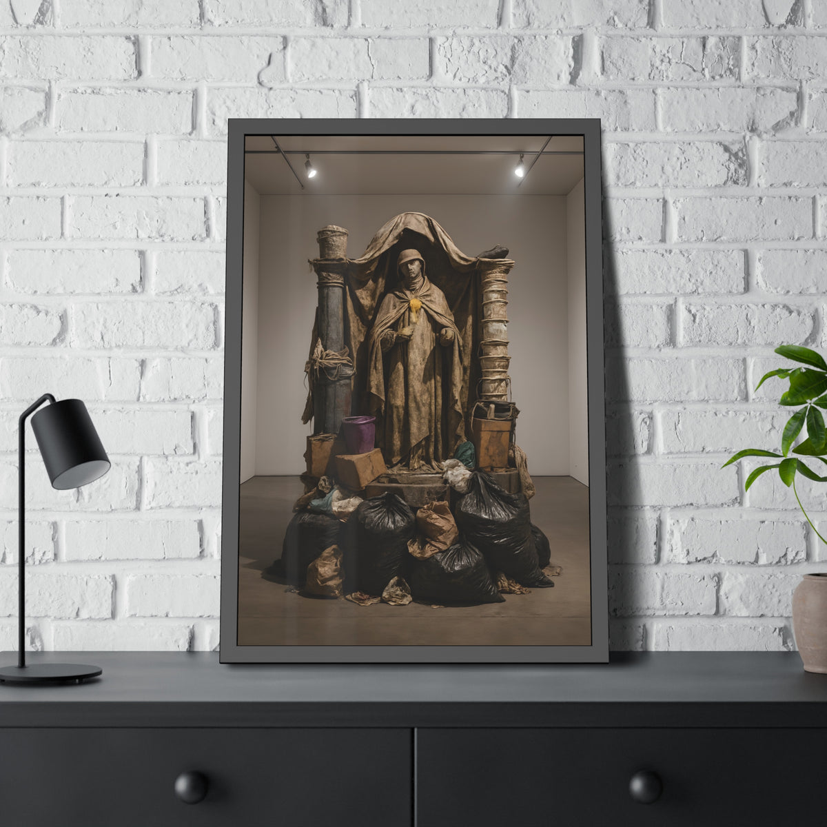 Draped standing figure under a canopy above a heap of black garbage bags. Saint Francis of the Black Bag by Garabaggio, framed fine art print hanging in a room.