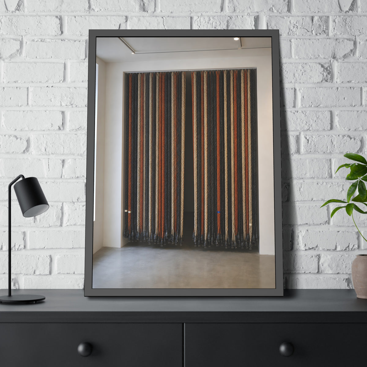 Hundreds of extension cords hung floor to ceiling across a bright white room. The Cord Curtain by Garabaggio, framed fine art print hanging in a room.