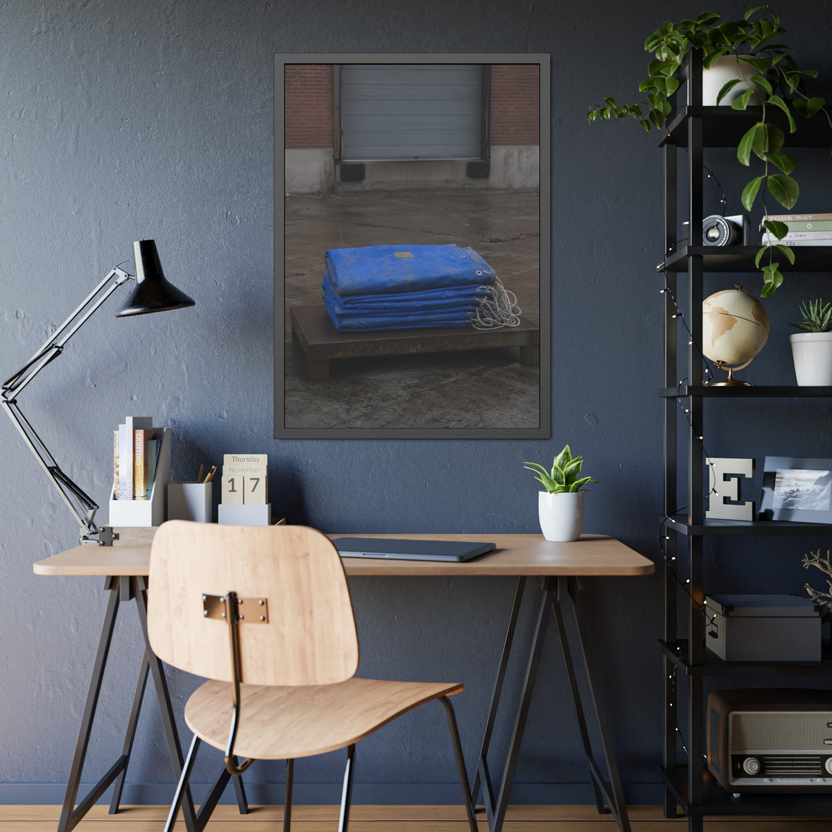 A folded blue tarp stacked on a low wooden platform by a loading dock. The Repaired Fold by Garabaggio, framed fine art print hanging in a room.