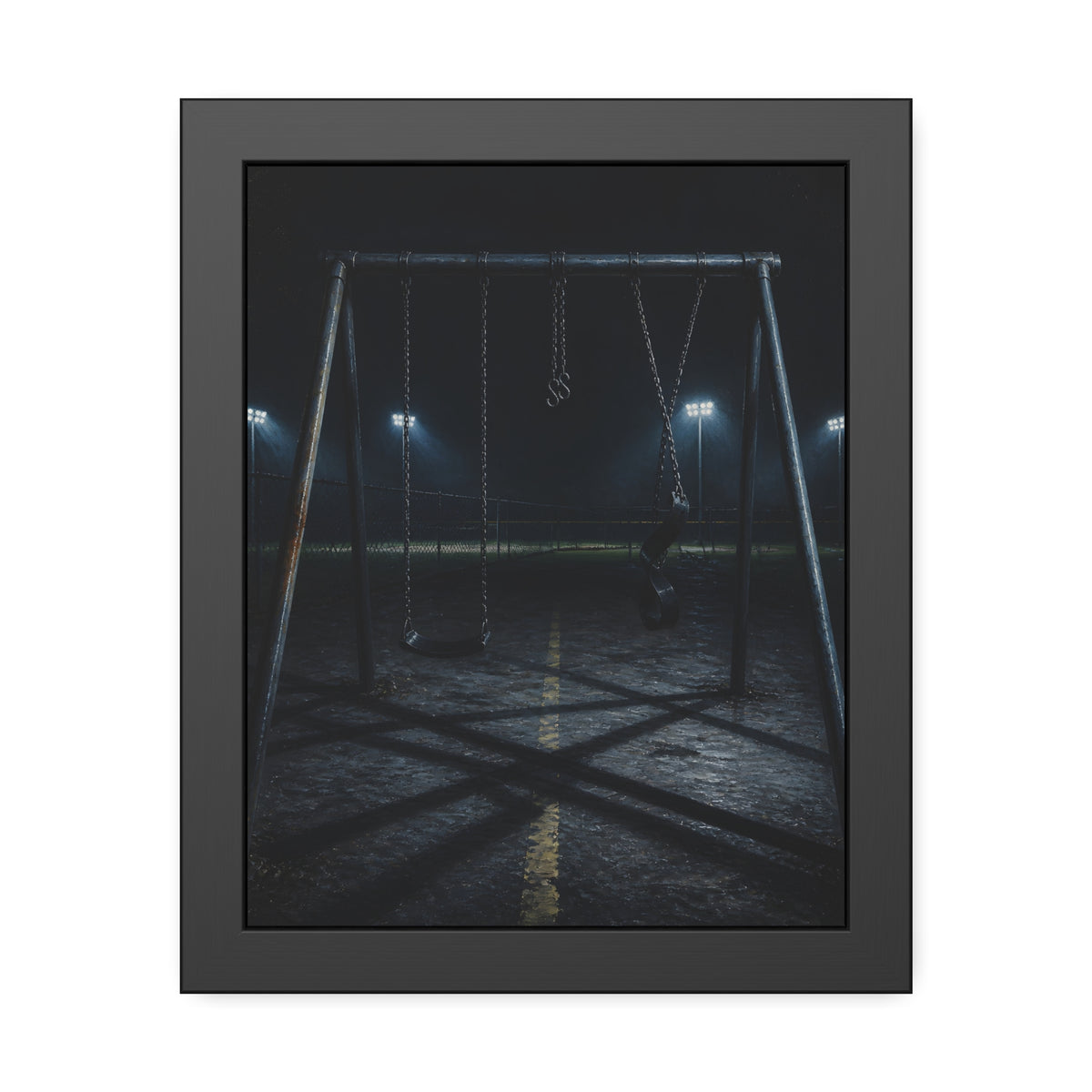 An empty swing set at night with field lights glowing behind it. The Ninth Hour: The Seat Still Moving by Garabaggio, framed fine art print, 11″ x 14″.