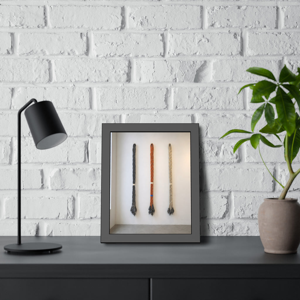Three braided bundles of extension cords hung on a white gallery wall. The Braided Triptych by Garabaggio, framed fine art print hanging in a room.