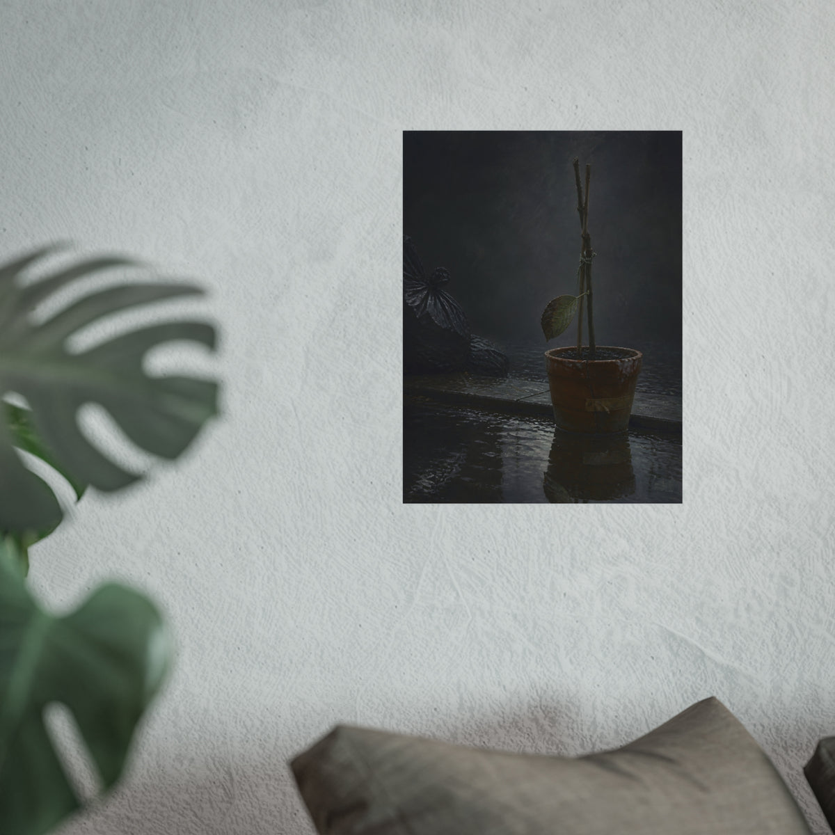Bare tied stems in a clay pot on flooded pavement, one leaf remaining. The Grey Between by Garabaggio, fine art print hanging in a room.