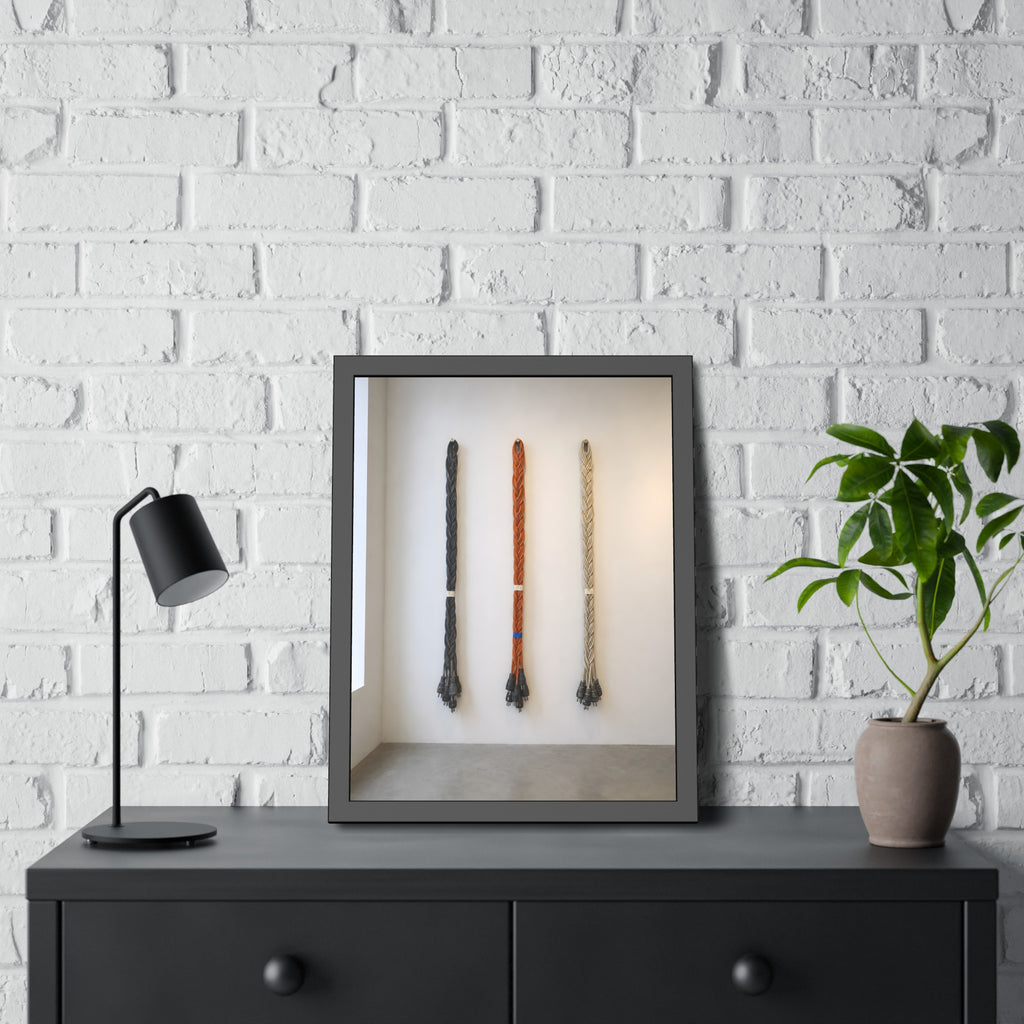 Three braided bundles of extension cords hung on a white gallery wall. The Braided Triptych by Garabaggio, framed fine art print hanging in a room.