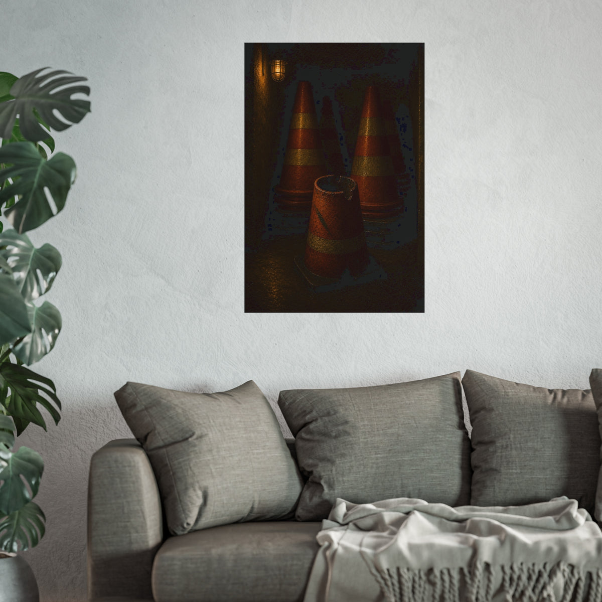 Stacked traffic cones behind a crushed one under a caged wall lamp. The Multiplication of Cones by Garabaggio, fine art print hanging in a room.