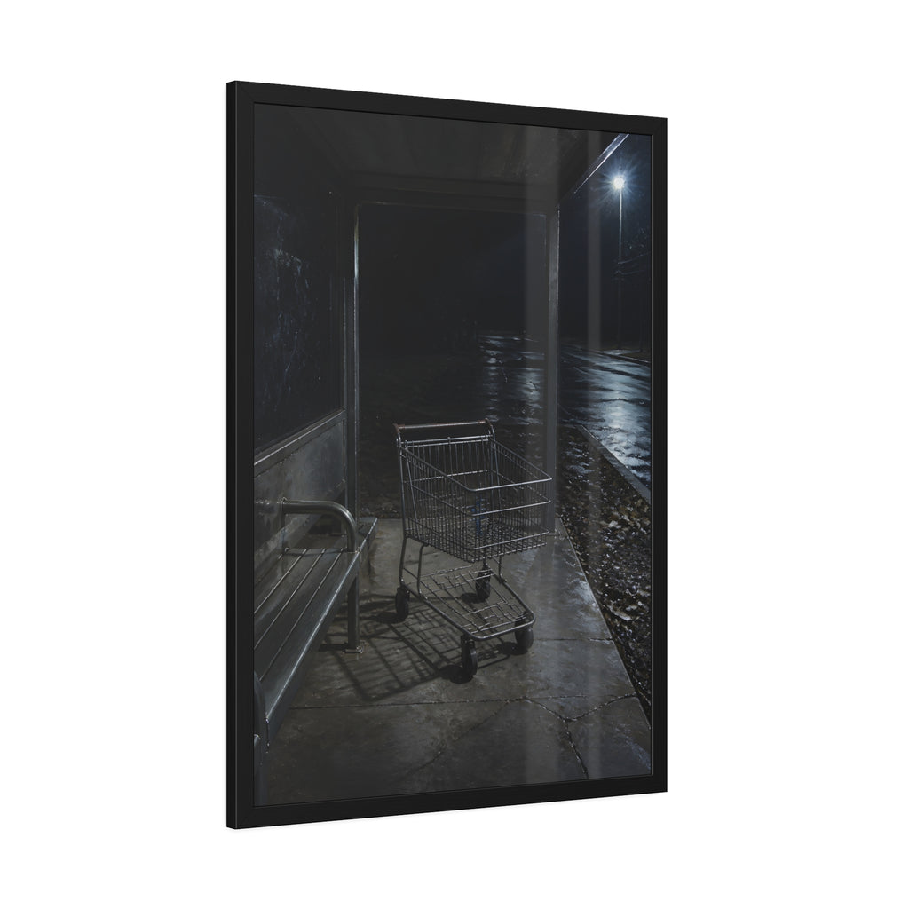A shopping cart parked inside a bus shelter under a street lamp at night. The Rest at the Bus Shelter by Garabaggio, framed fine art print hanging in a room.