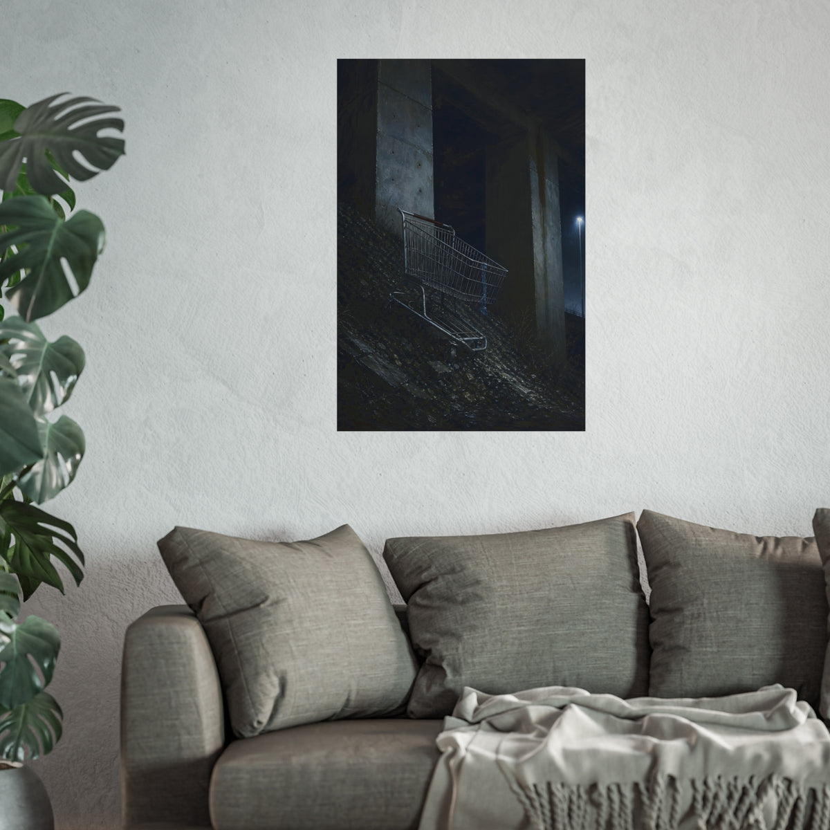 A shopping cart on a rocky slope under an overpass near a streetlamp. The Descent to the Underpass by Garabaggio, fine art print hanging in a room.