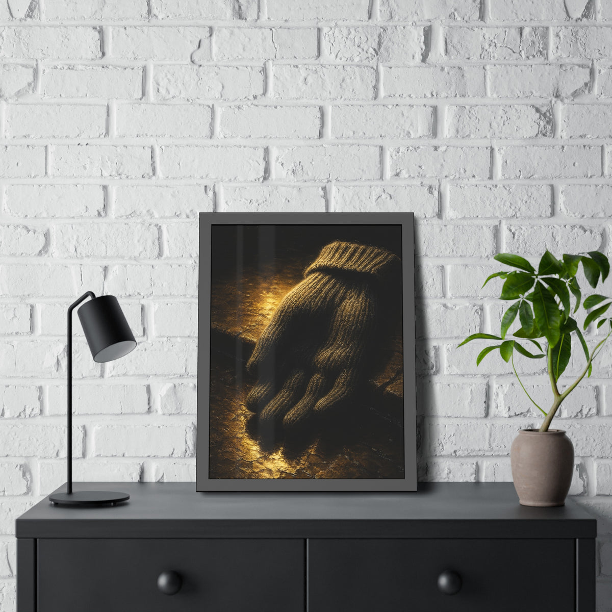 A knitted wool glove palm down on wet stone in gold light. The Presentation of the Woolen Glove by Garabaggio, framed fine art print hanging in a room.