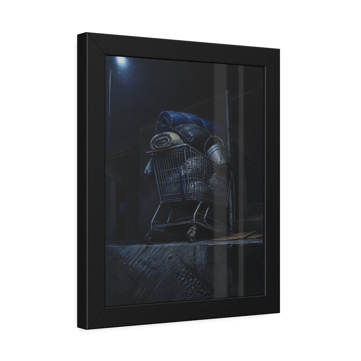 A shopping cart piled with bedding and buckets under a streetlamp. The Loading of Another Life by Garabaggio, framed fine art print hanging in a room.