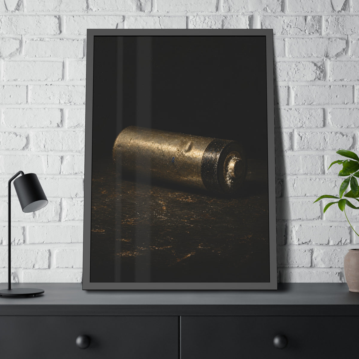 A corroded AA battery lying on a dark gritty surface in a single beam. The First Exhaustion by Garabaggio, framed fine art print hanging in a room.