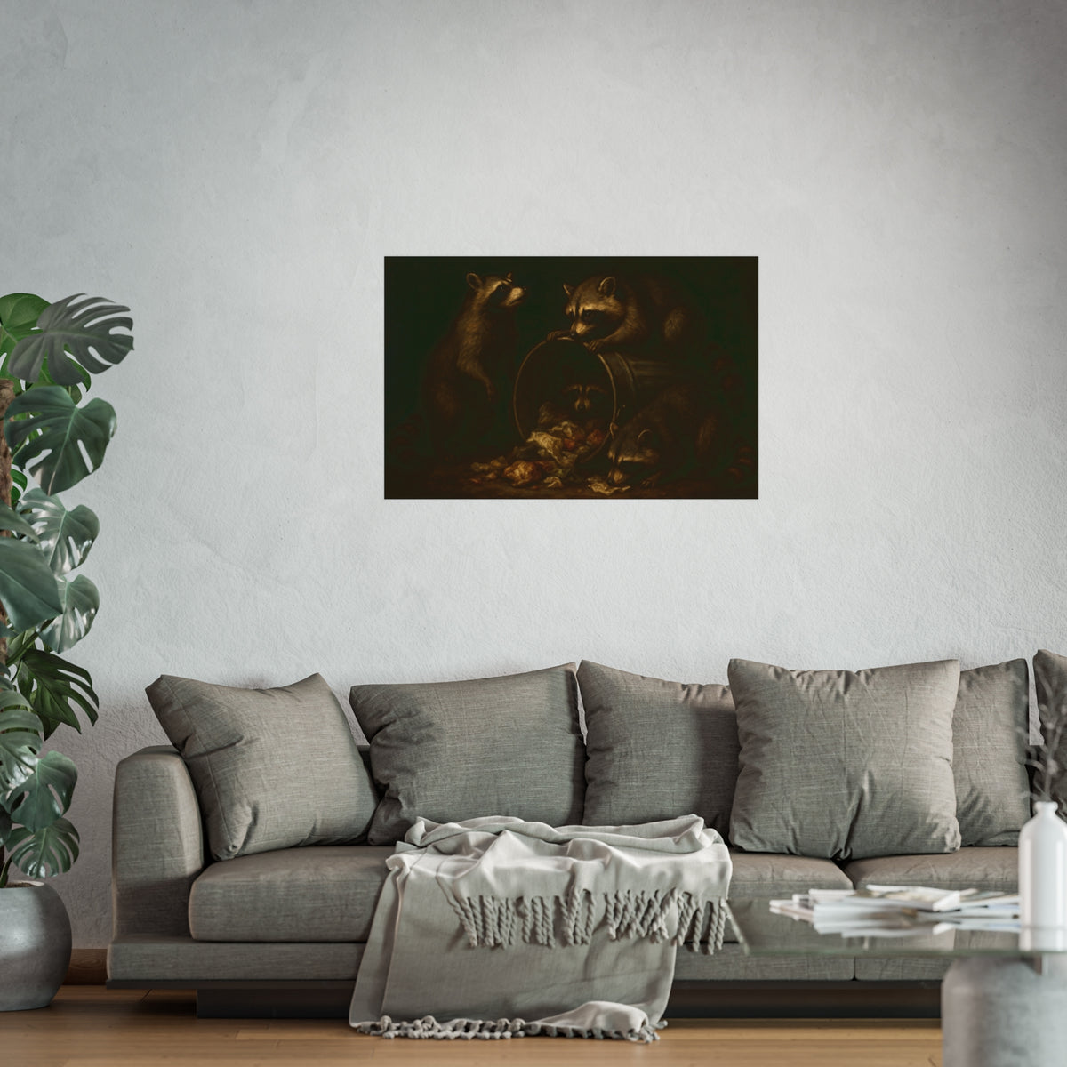 Four raccoons around a tipped metal trash can spilling food scraps. The Crowning with Crumbs by Garabaggio, fine art print hanging in a room.