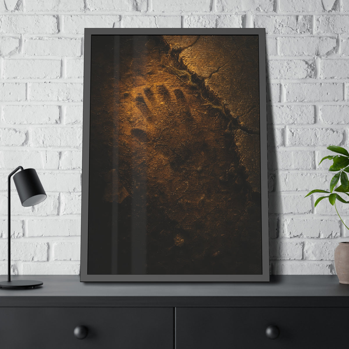 A glove shaped imprint left in cracked asphalt under warm light. The Assumption, or: What Remains by Garabaggio, framed fine art print hanging in a room.