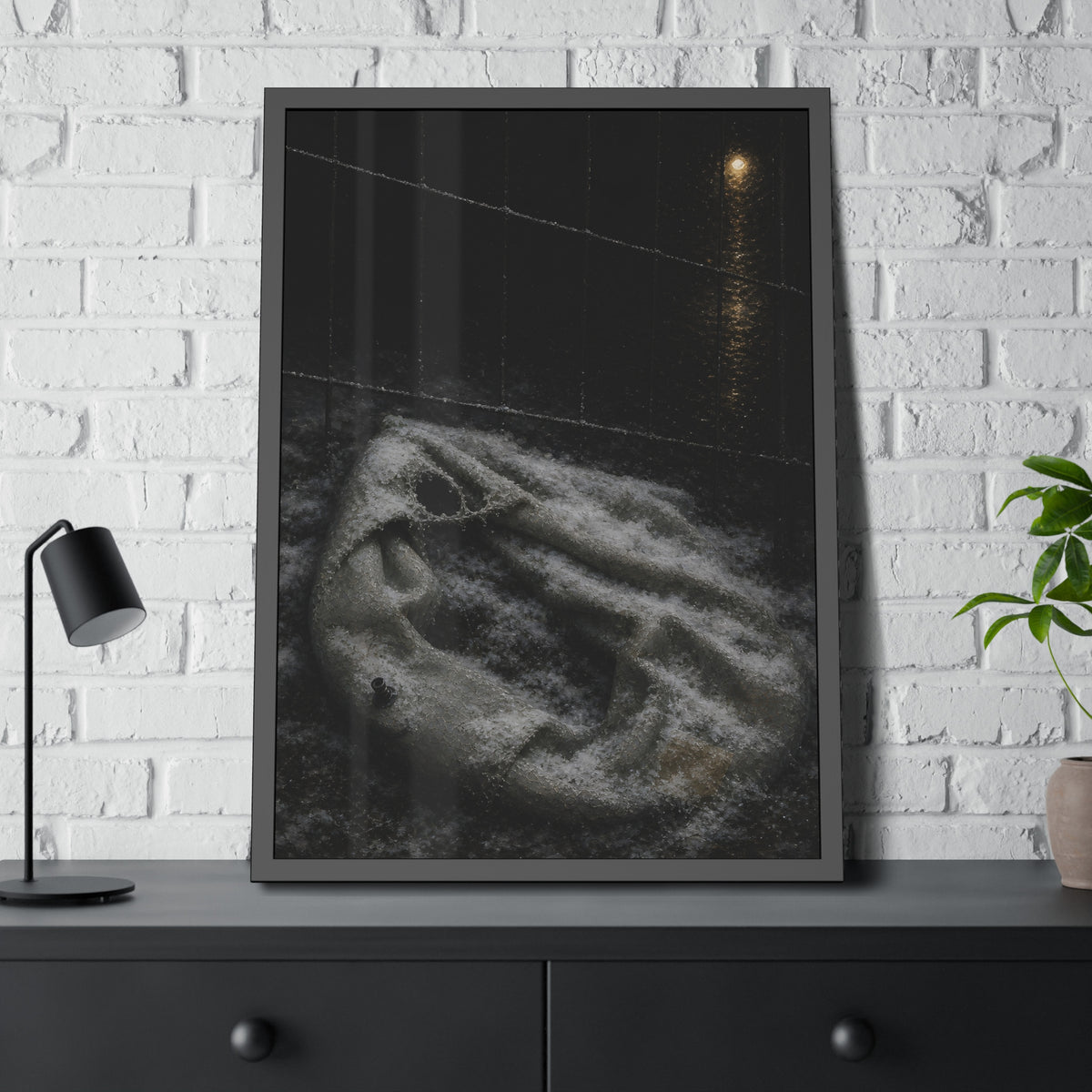 A deflated pool float under snow beside a chain link fence at night. The Bleaching Under Snow by Garabaggio, framed fine art print hanging in a room.