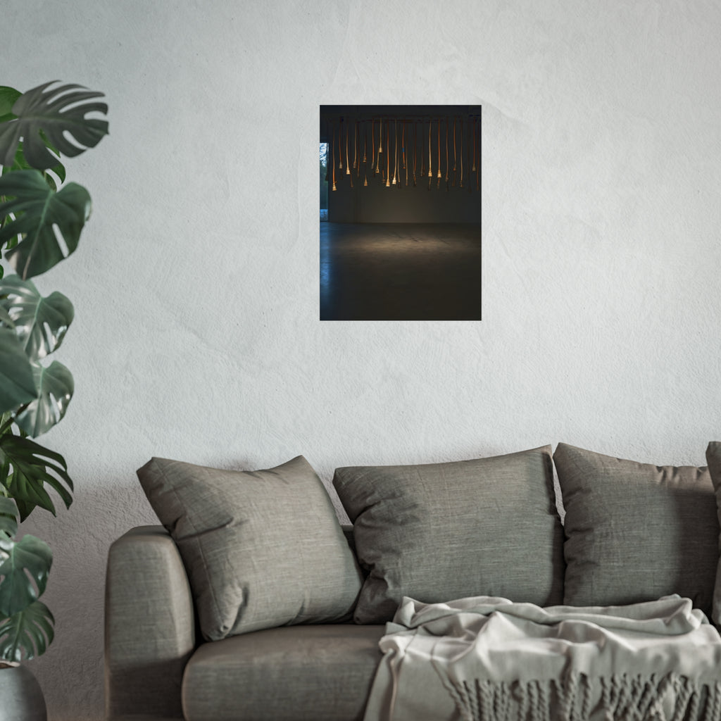 Extension cords hanging plug down from a ceiling in a dim room. All Ends, No Source by Garabaggio, fine art print hanging in a room.