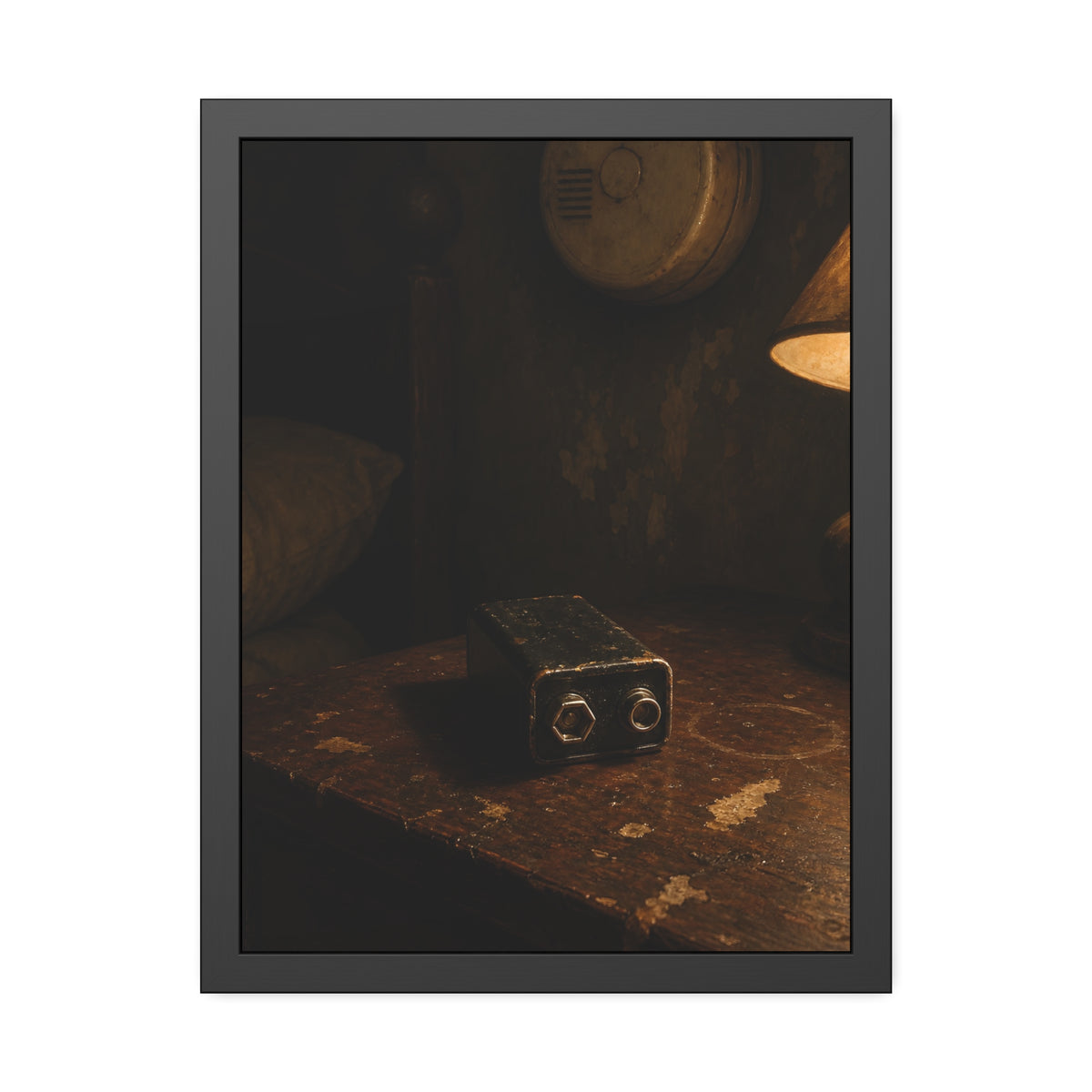 A nine volt battery on a nightstand below a wall smoke detector. The Battery Laid Below by Garabaggio, framed fine art print, 18″ x 24″.