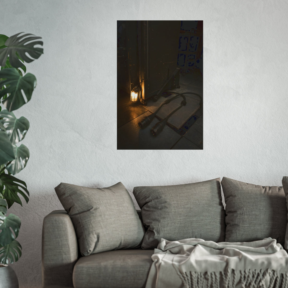 Two thick power cables unplugged on the floor beside a caged work lamp. The Redundant Power by Garabaggio, fine art print hanging in a room.