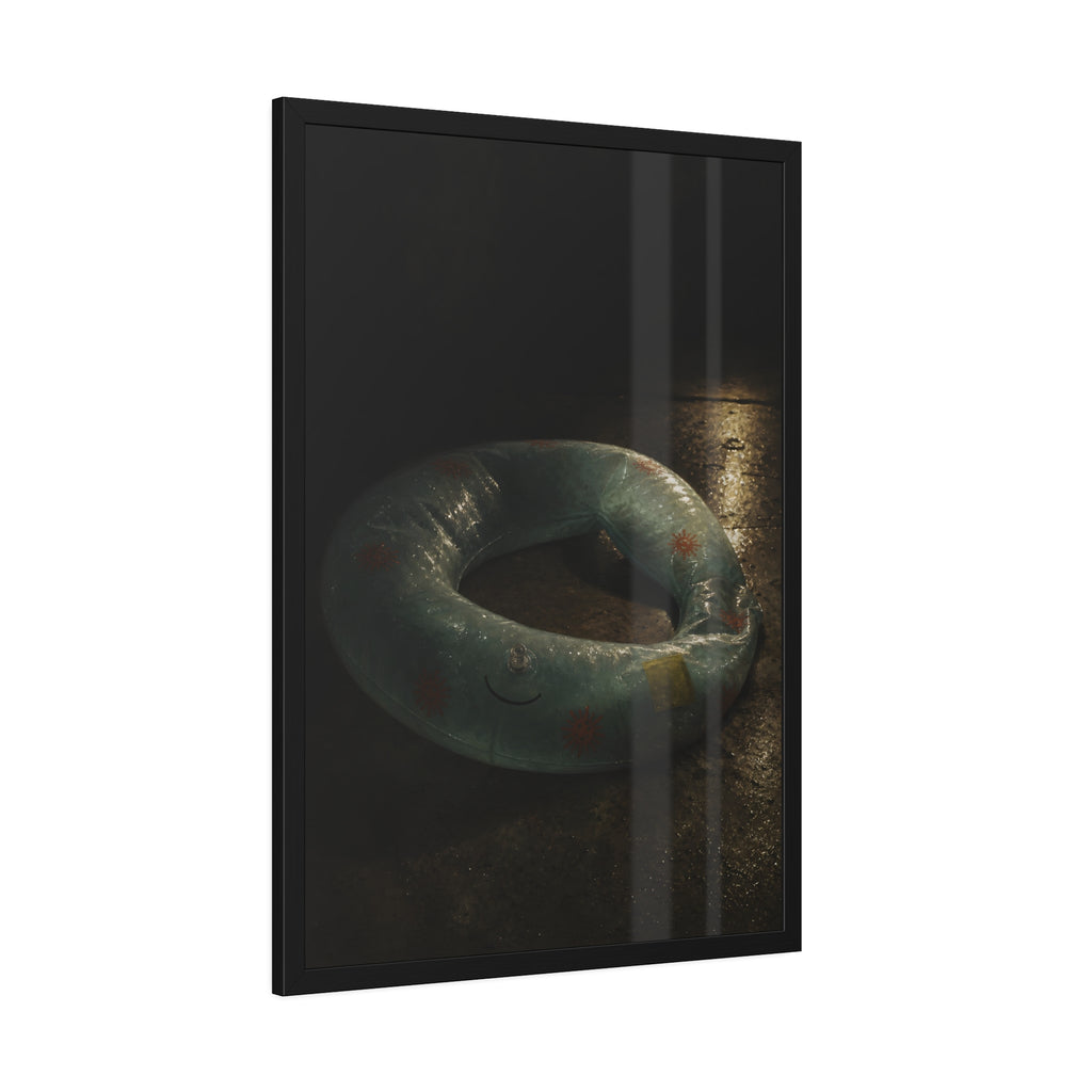 Deflated pool float ring on wet ground, lit from one side in the dark. After the Last Swim by Garabaggio, framed fine art print hanging in a room.