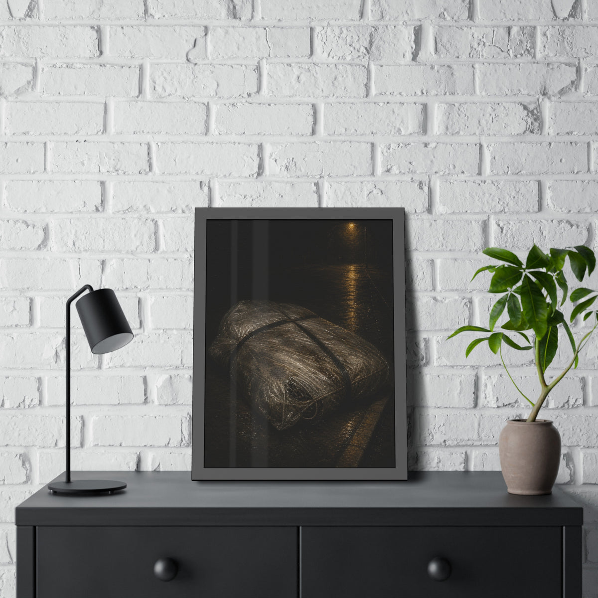 A mattress wrapped in plastic and strapped shut on a wet night street. The Municipal Shroud by Garabaggio, framed fine art print hanging in a room.