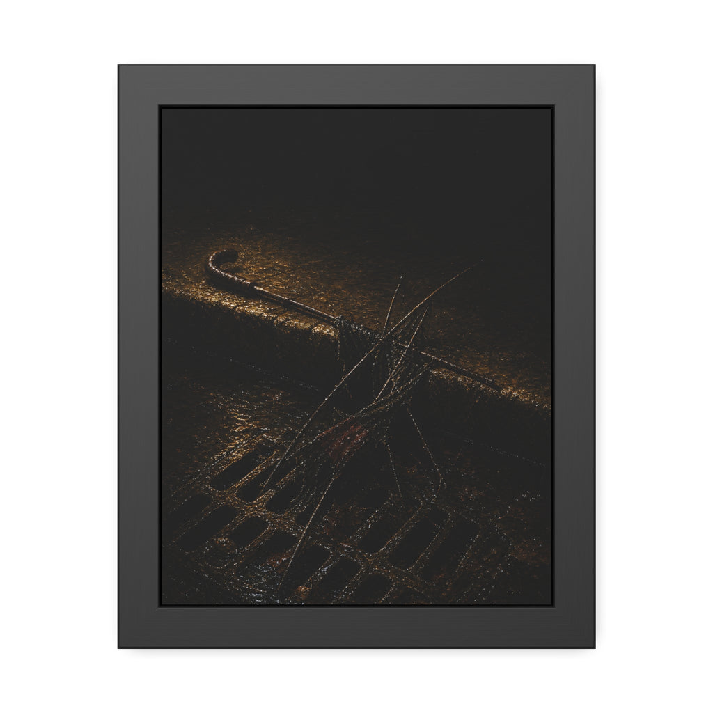A broken umbrella collapsed across a storm drain grate at the curb. The Burial at the Storm Drain by Garabaggio, framed fine art print, 11″ x 14″.