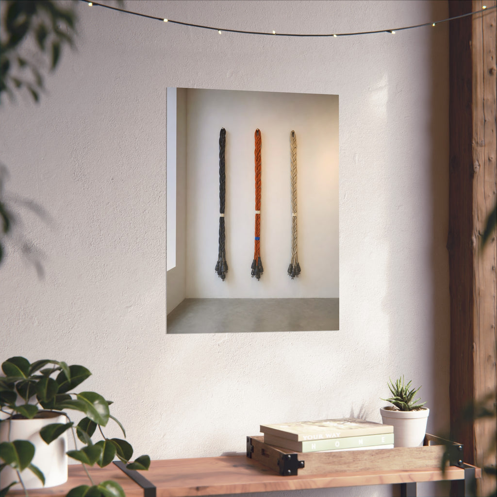 Three braided bundles of extension cords hung on a white gallery wall. The Braided Triptych by Garabaggio, fine art print hanging in a room.